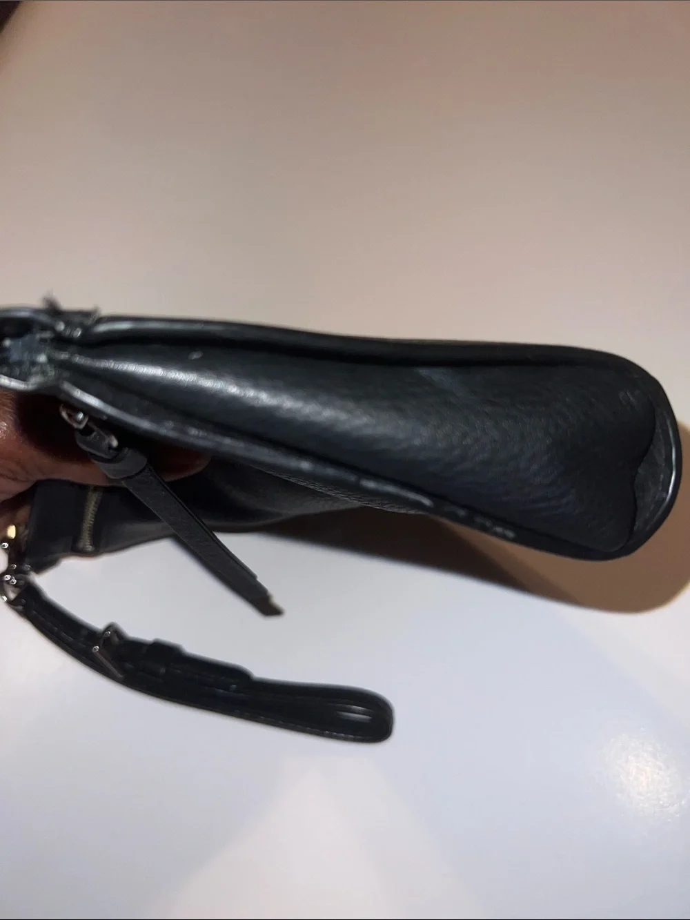 Coach Black Pebbled Leather Wristlet featuring silver hardware and a top zipper.